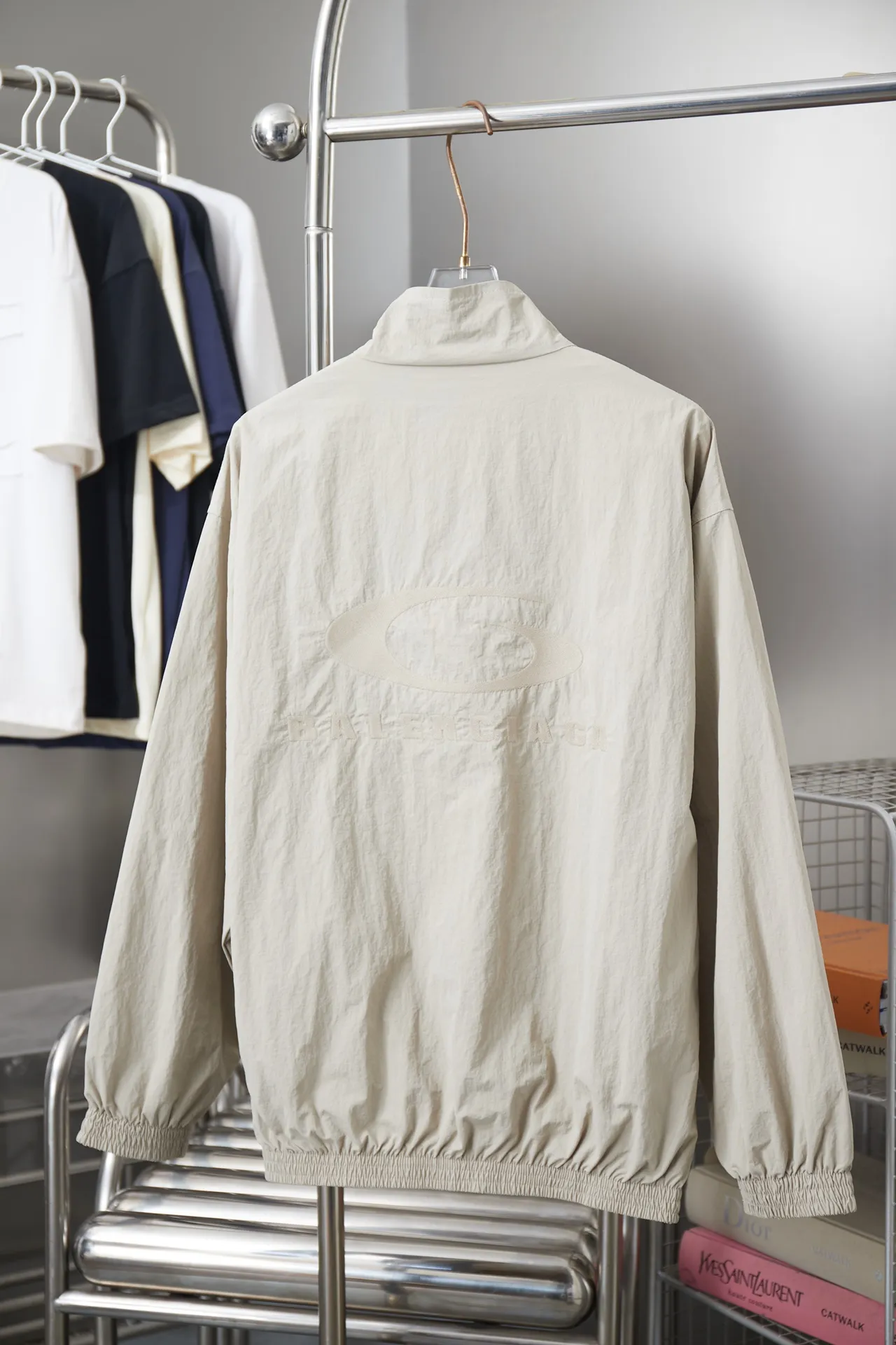 Balenciaga 𝘽𝘼𝙇𝙀𝙉𝘾𝙄𝘼𝙂𝘼 BLCG 26SS 71 front and rear half-circle letter embroidered sports suit Light luxury essential item for daily commuting for men and women Correct version Welcome to compare Detailed features · Customized matt Taslan jacket fabric · The fabric has undergone a waterproof coating process · The interior is made of three-grade polyester bird's eye mesh · OS ultra-loose silhouette design · Side zipper pockets Small stand-up collar design · Internal zipper pocket design · Elastic waistband design at the hem · Customized molded hardware zippers Jacket double puller design · Tajima high-speed embroidery machine with 100,000-needle three-dimensional design · Double side pockets on trousers · Original main mark washed tag brand packaging Color: Black/Milk Apricot Size: 46/48/50/52
